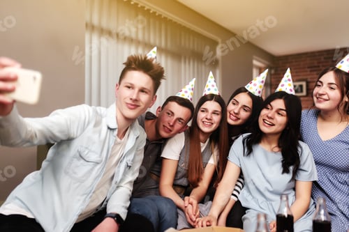 Visualização: Grupo de melhores amigos com boné festivo tomando selfie na festa de aniversário