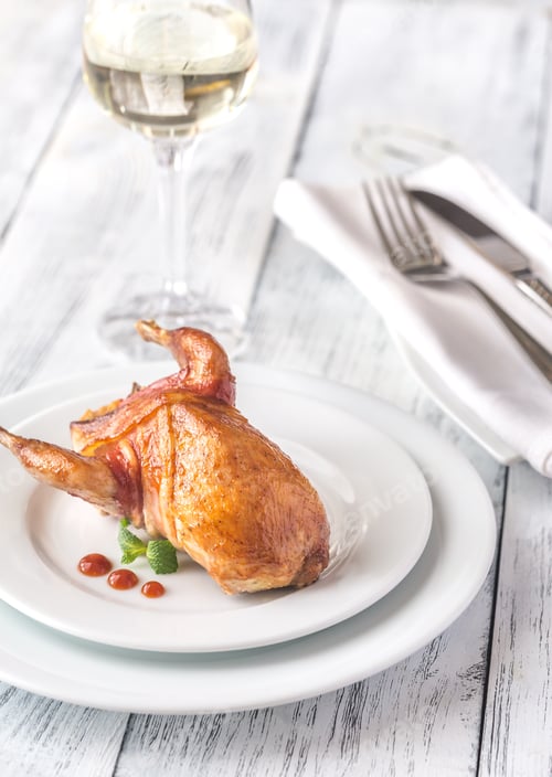 Preview: Baked quail wrapped in bacon on the plate