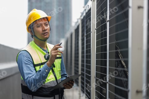 Vista previa: Un ingeniero que usa una tableta trabajando en la construcción de un edificio en la azotea.