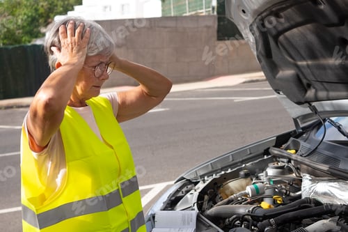 Preview: An elderly woman with her hands in her hair, desperate for her car to break down on the street