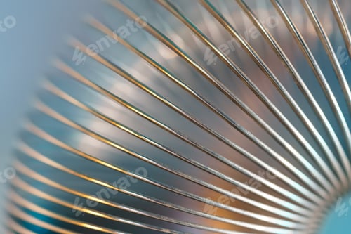 Preview: Closeup of coiled metal spring with sufficiently high strength and elastic properties in neon light
