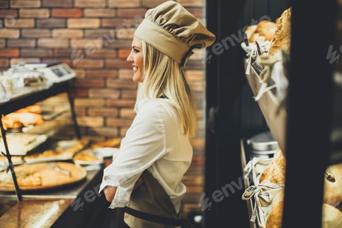 Preview: Young woman selling bread in baker shop