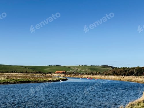 Preview: Kayakers on a calm river near Seven Sisters Cliffs in East Sussex, UK