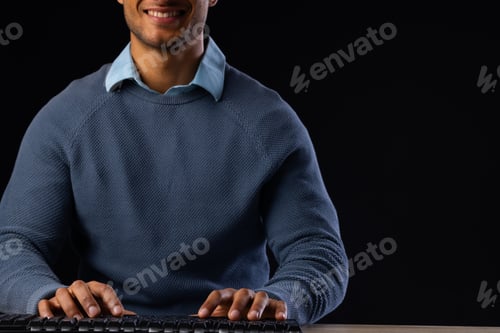 Preview: Biracial businessman using computer with copy space on black background