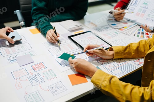 Preview: Close up view of UI developer team brainstorming on their project with laptop, smartphone