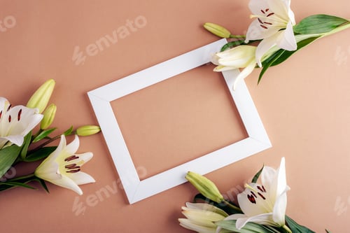 Preview: White lilies and a white rectangular picture frame on a beige background, mockup
