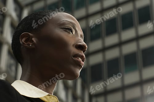 Preview: Contemplative woman against an urban backdrop