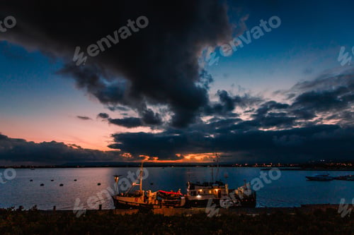 Preview: Moored boat illuminated during sunset
