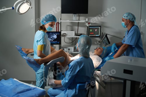 Preview: Hospital staff wearing uniform doing ultrasound examination to pregnant woman