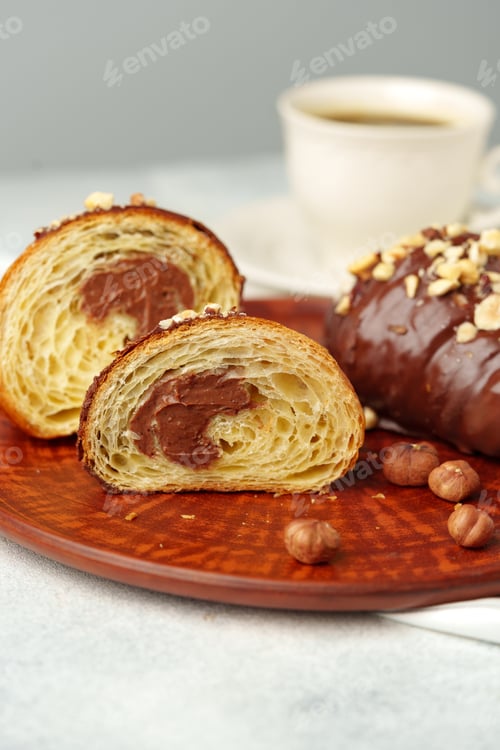 Preview: Chocolate croissant on clay plate with cup of coffee on table