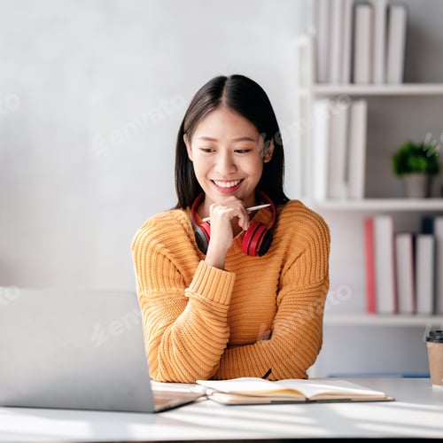 Preview: Distance education learning, Young woman in sweater studying education lesson online and writing