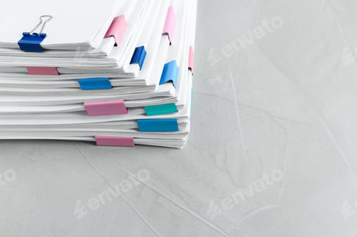 Preview: Stack of documents with binder clips on light table