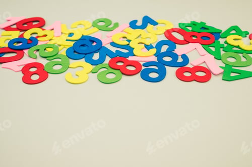 Preview: Closeup of the colorful wooden numbers scattered on a green surface - space for te