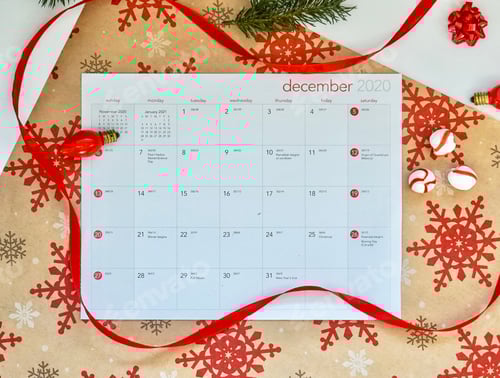 Visualização: Visão aérea de um calendário de dezembro: fitas vermelhas, luzes e doces de hortelã