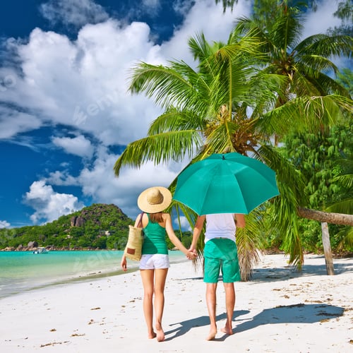 Preview: Couple In Green With Umbrella On A Tropical Beach At Seychelles