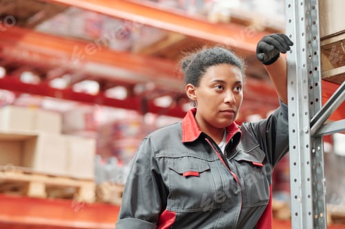 Preview: Middle aged mixed-race female worker in gloves and grey uniform having rest