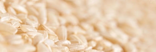 Preview: A background of dry brown rice grains showcases the integral, uncooked texture