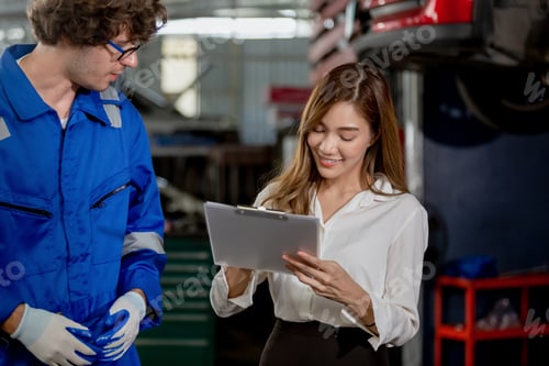 Preview: Man garage worker and woman customer talking to discuss the details of car repairs.