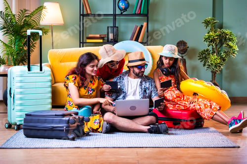 Preview: Indian parents and kids with laptop and suitcases booking a vacation trip online