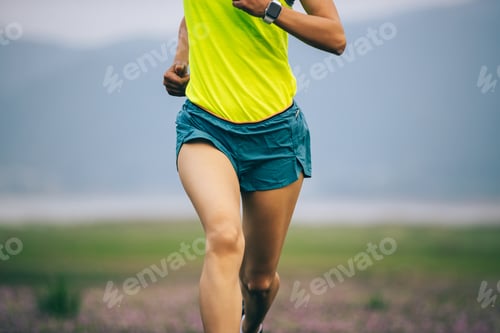 Preview: Female runner running in spring wild field