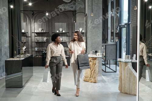 Preview: Young intercultural females in elegant casualwear moving along jewelry store