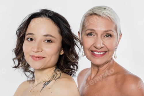 Preview: Smiling senior woman with naked shoulders near friend isolated on grey, feminism concept