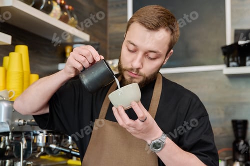 Preview: Young male barista preparing coffee in coffee shop