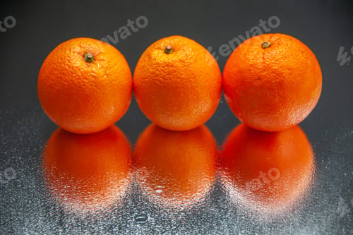 Preview: Above view of fresh oranges standing side by side on light on black background with free space