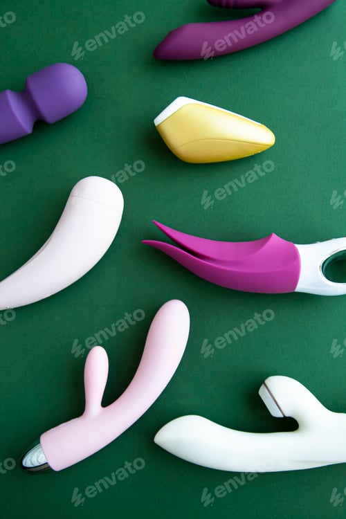 Preview: Collection of different types of sex toys on a green background.