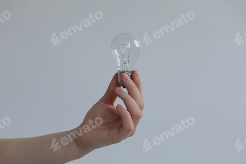Preview: Hand Holding a Lightbulb in a Studio Setting