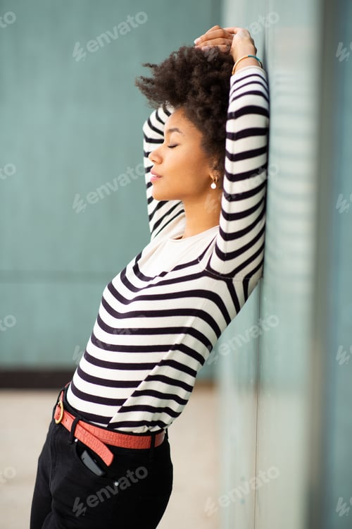 Preview: Stylish young black woman model leaning to wall