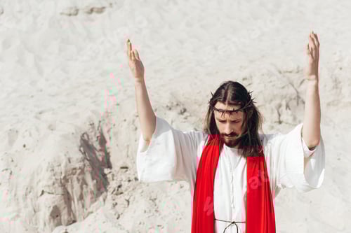 Preview: Jesus standing with raised hands and praying in desert