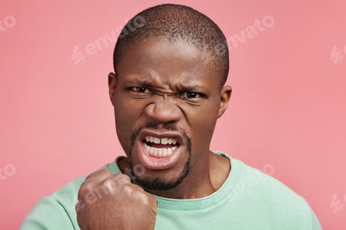 Preview: Outraged furious dark skinned man threatens with fist, has quarrel, screams in terror, shows his str