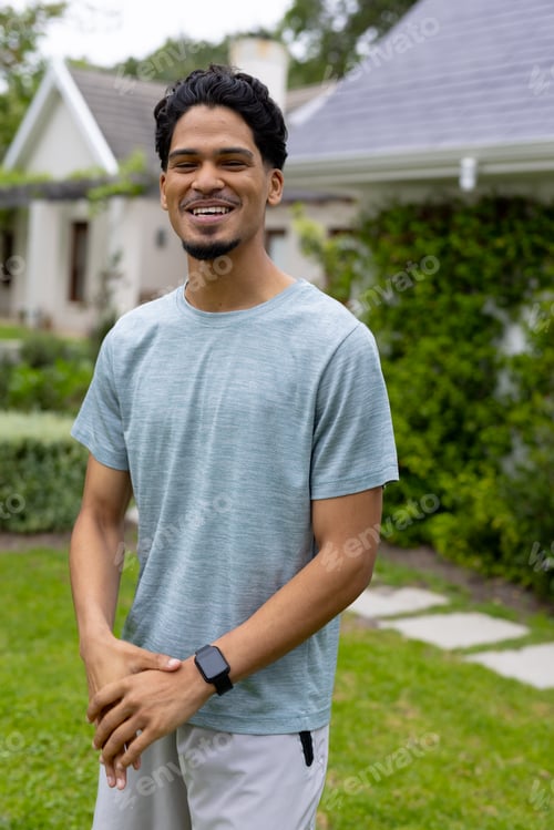 Preview: Smiling young man enjoying sunny day in garden, wearing casual outfit