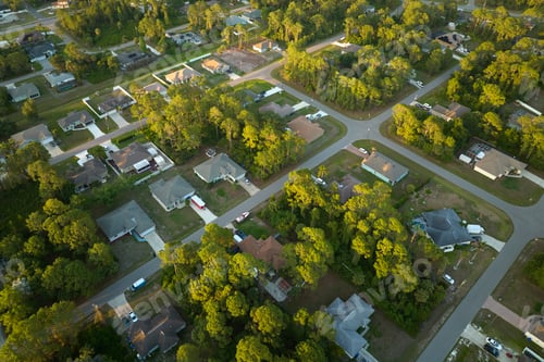 Preview: Aerial view of suburban landscape with private homes between green palm trees in Florida