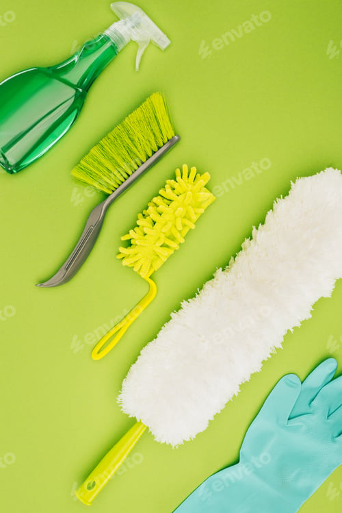 Preview: top view of different cleaning brushes and rubber glove isolated on light green