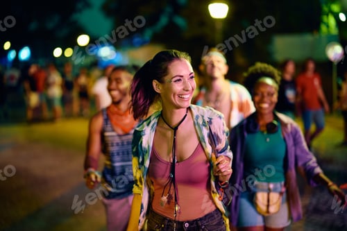 Preview: Happy woman and her friends on summer music festival at night.