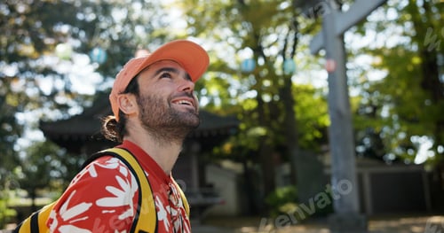 Preview: Outdoor, thinking and man with a smile, travel and nature with sunshine, Japanese and tourism. Pers