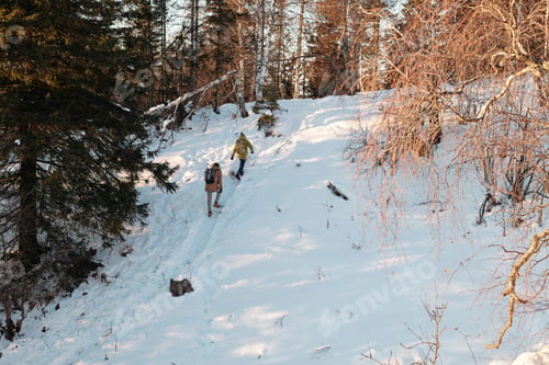 Preview: Two people with backpacks ascending hill while moving down footpath