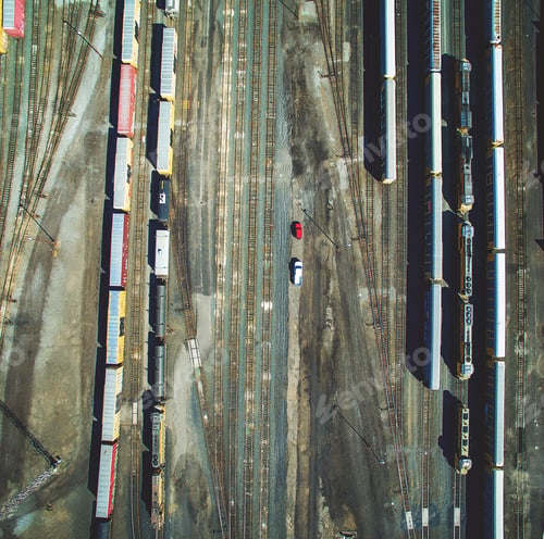 Preview: Straight looking down aerial shot from drone over a railway with many railroad tracks and cars.