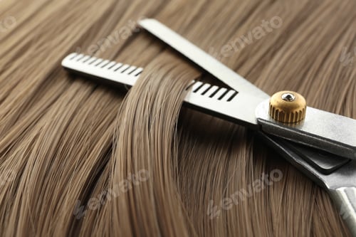 Preview: Thinning scissors on light brown hair, closeup. Hairdresser service
