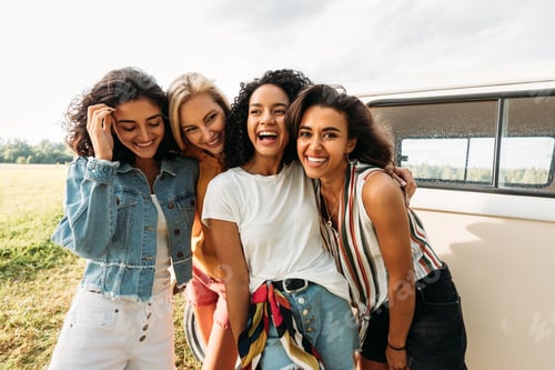 Preview: Young laughing women standing at van having good times during summer vacation