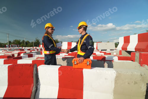 Preview: Two surveyor of construction engineer, architect, in hardhat working on construction site.
