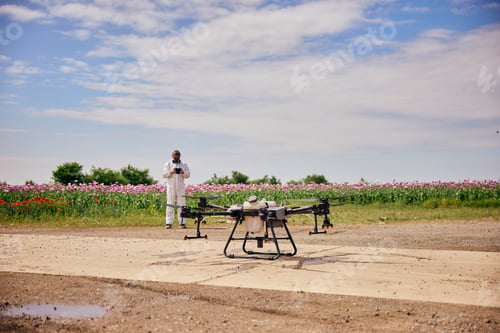 Preview: Male operator in the background starting the agro drone with a controller.