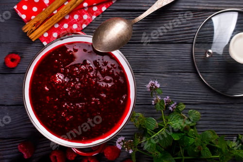 Preview: Raspberry jam with berry on dark background.