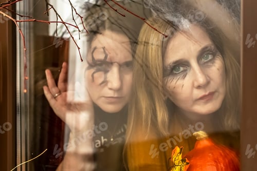 Preview: Two witches look through out of the window of Halloween decorations. Masquerade, Halloween party