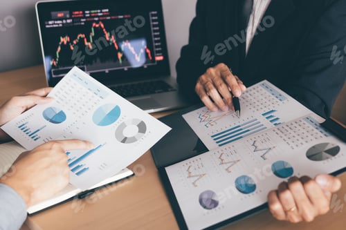 Preview: investors are working together with analyzing the stock data graphs in the paper