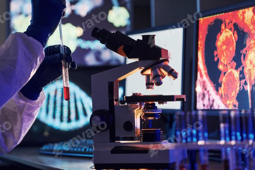Preview: Scientist in white protective uniform works with coronavirus and blood tubes in laboratory