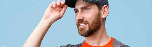 Preview: Close up of male worker in uniform holding cap and smile looking at side. Studio