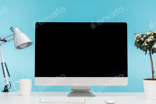 Preview: workplace with computer, lamp, cup and flowerpot on white table on blue background